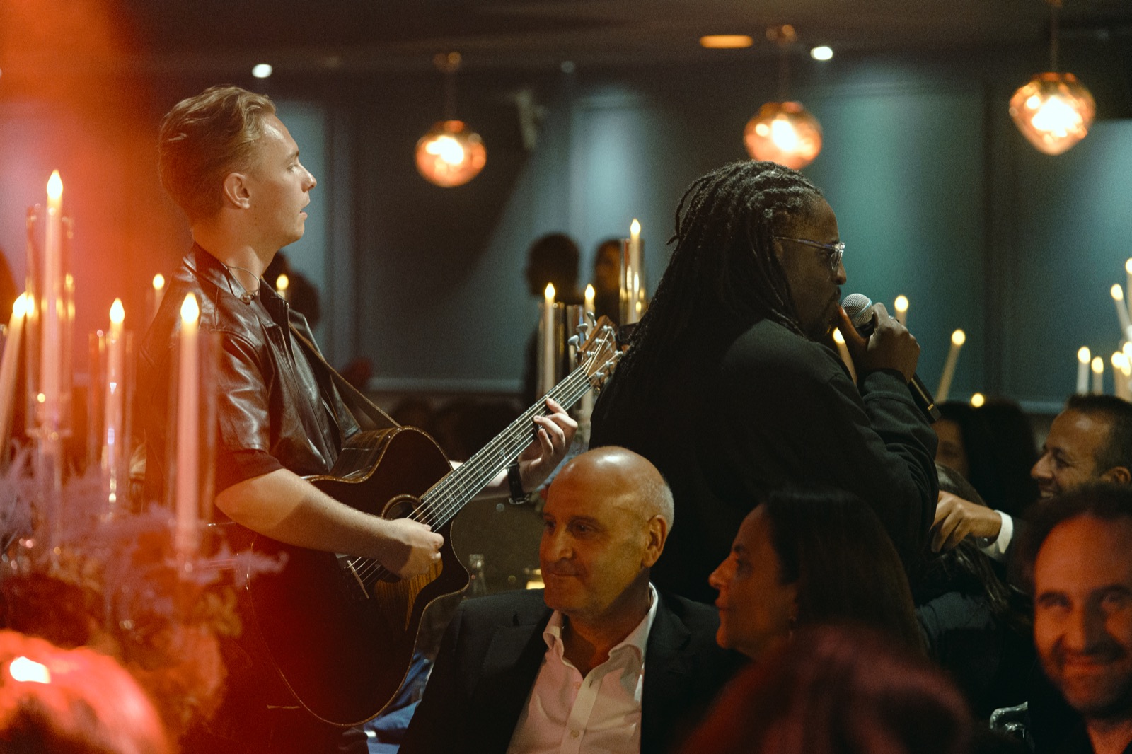 Guitariste et chanteur entre les tables d’un dîner aux chandelles, Drop Music