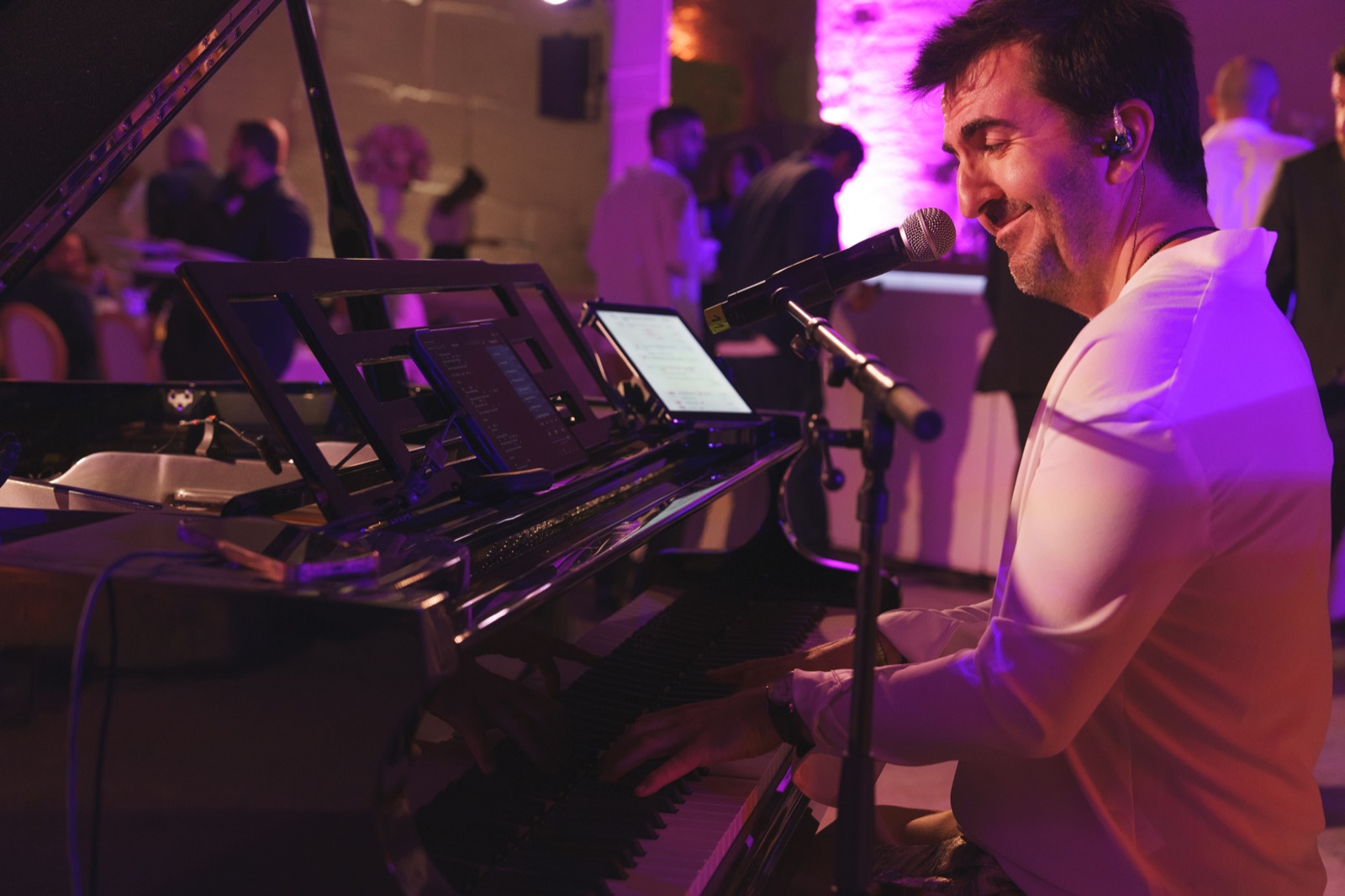 Pianiste chanteur au micro, piano éclairé en rose pendant un dîner, Drop Music
