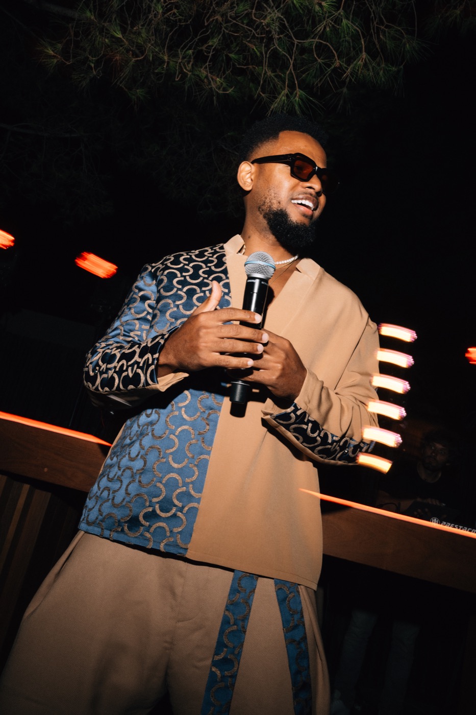 Chanteur au micro en extérieur, la nuit, pendant un cocktail, Drop Music