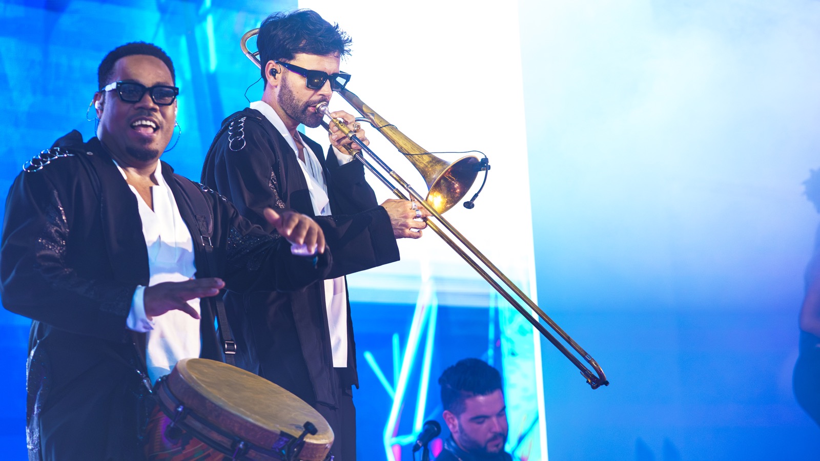Tromboniste et percussionniste devant un écran bleu pendant un set, Drop Music