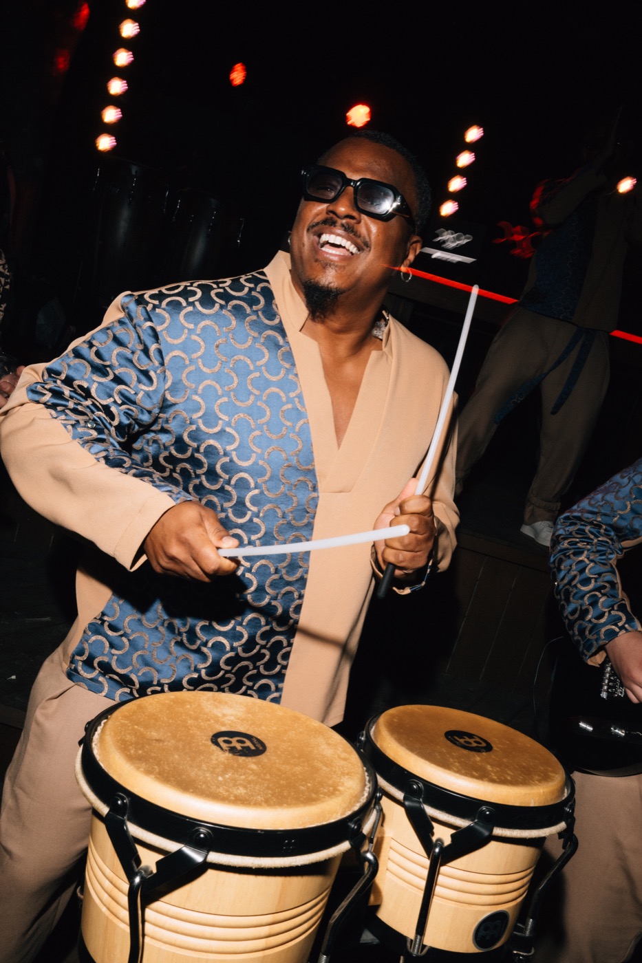 Percussionniste aux congas, baguettes en main, pendant une soirée, Drop Music