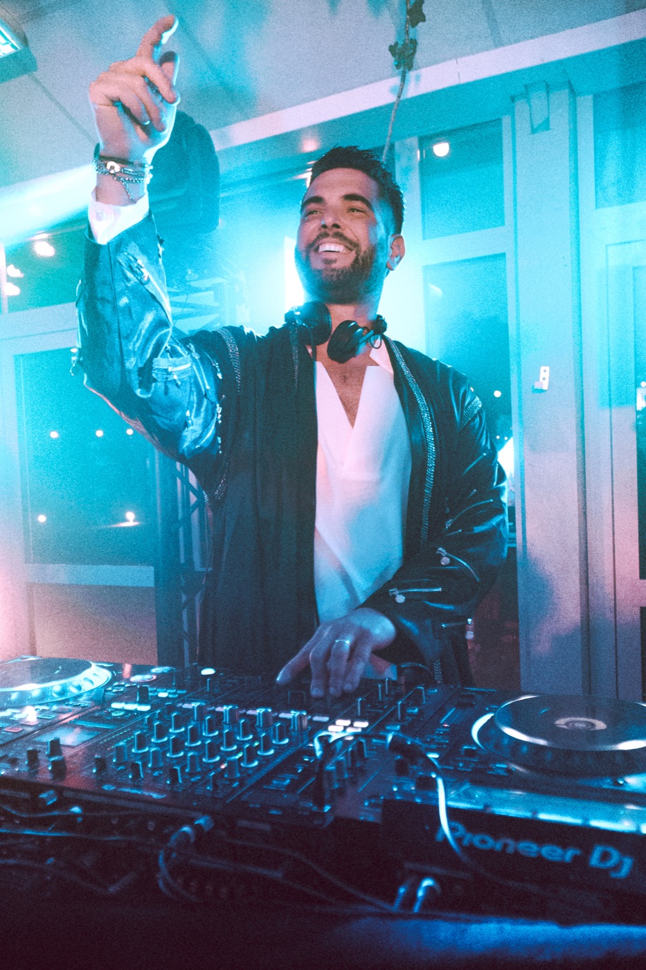 DJ aux platines, bras tendu vers la piste, lumière bleue, Drop Music