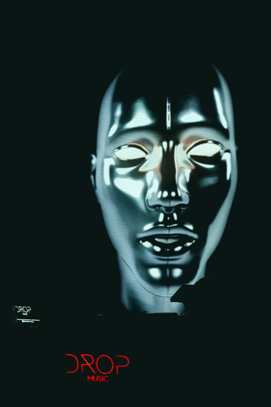 Visage projeté en mapping sur une façade, la nuit, Drop Music