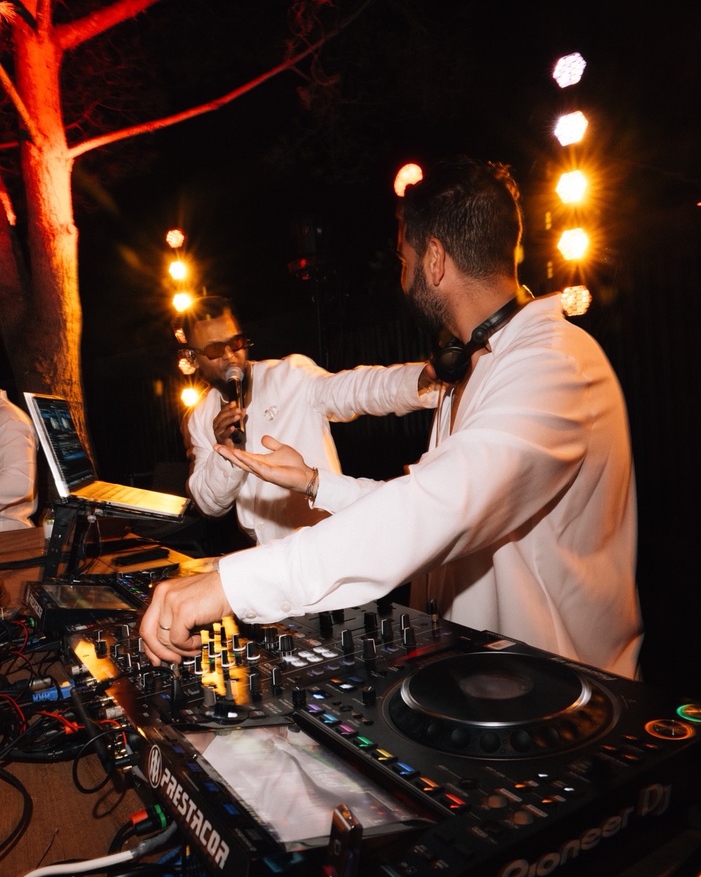 DJ aux platines et chanteur au micro en extérieur, la nuit, Drop Music